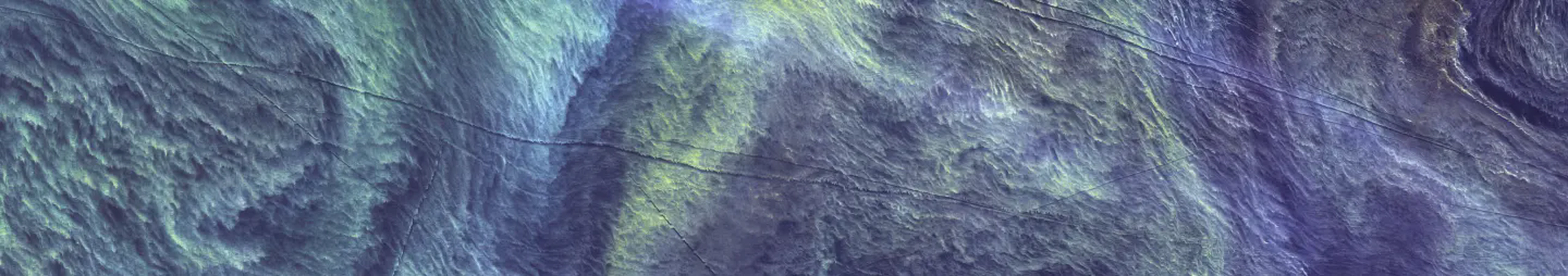 Satellite view of the ocean with swirling patterns and thin dark lines.